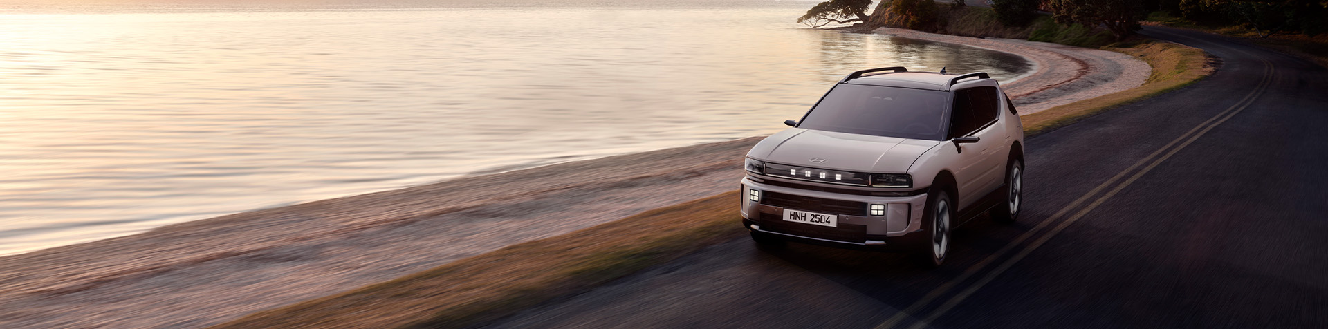 The all-new Hyundai NEXO drives across a wide beach on a sunny day