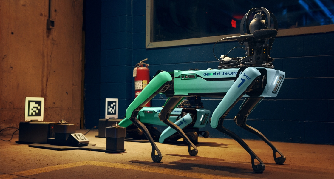 The Spot robot running along on all 4 legs with a second Spot robot behind.